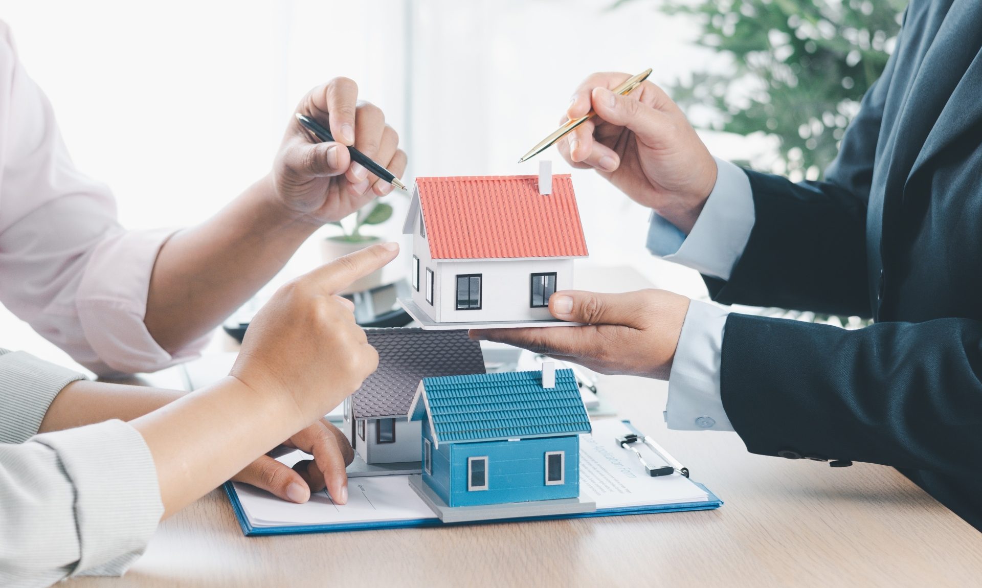 real estate house Business meeting with miniature house model representing mortgage vs payment plan options in The Gambia real estate market, highlighting financing strategies for foreign property buyers in 20