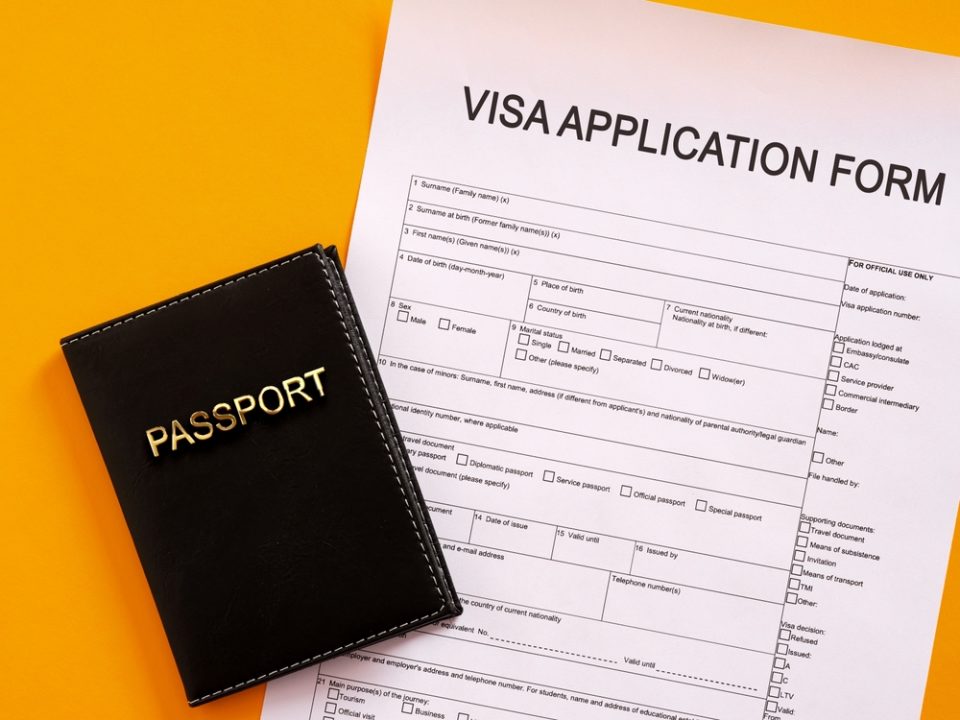 visa and passport Black passport cover placed on visa application documents representing Uruguay digital nomad visa requirements, costs, and relocation process for international remote workers in 2026.